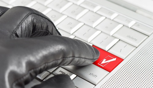 zwarte leren handschoen drukt op rode enter op toetsenbord